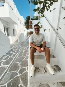 Dr. Raamis Hirani sitting on stone steps